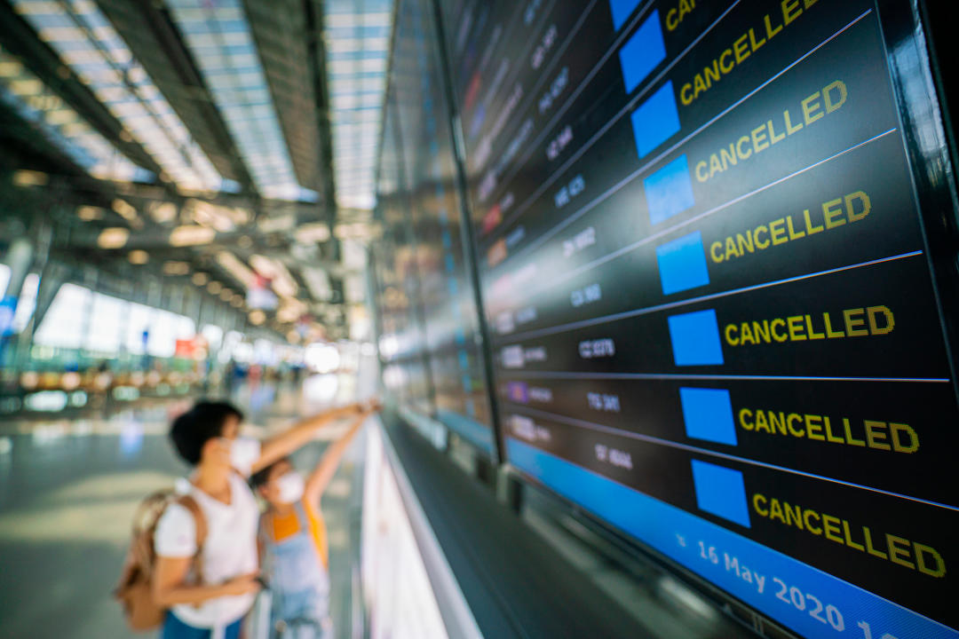 Мандрівники дивляться на табло з інформацією в аеропорту