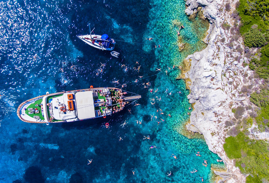 Люди купаються у блакитних водах острова Антипаксос