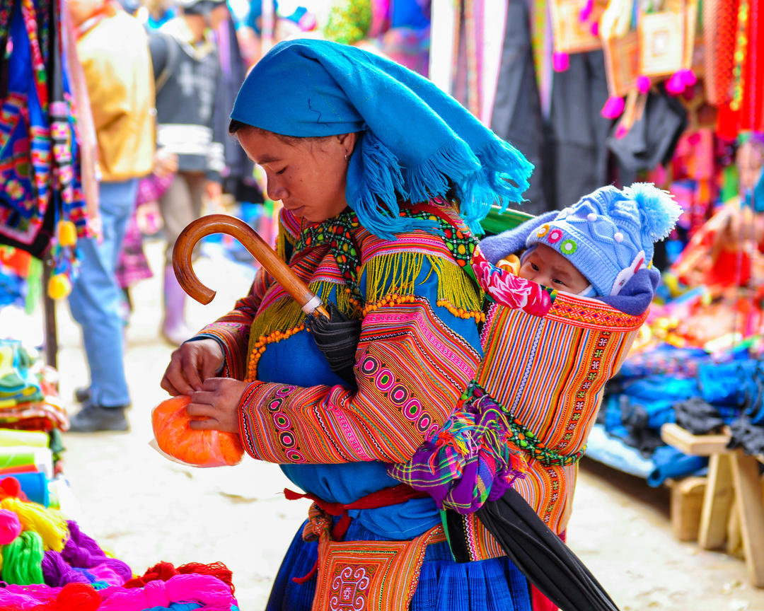 Дівчина в яскравому одязі з дитиною на ринку