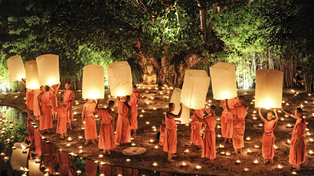 Монах запалює повітряну кулю з паперу у храмі Ват Фан Тао