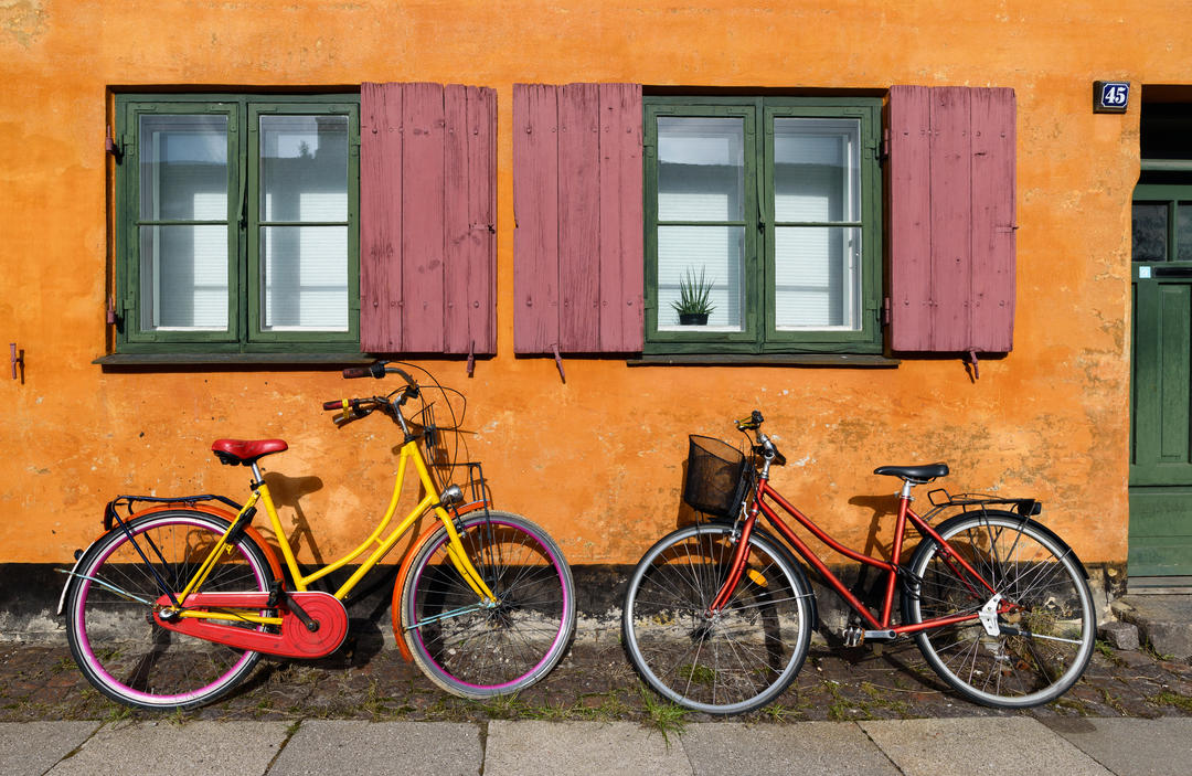 Велосипеди перед помаранчевим фасадом будинку