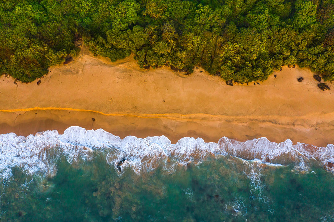 Морські хвилі покриває помаранчевий пісок пляжу в Гоа