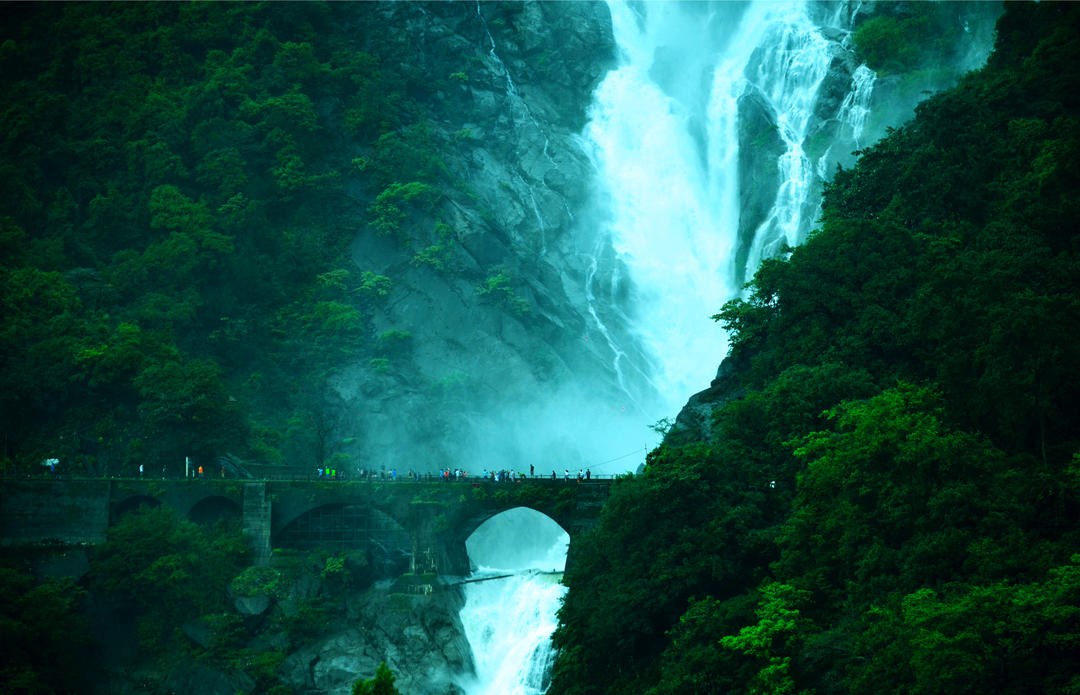 Кам'яний міст на водоспаді з туристами