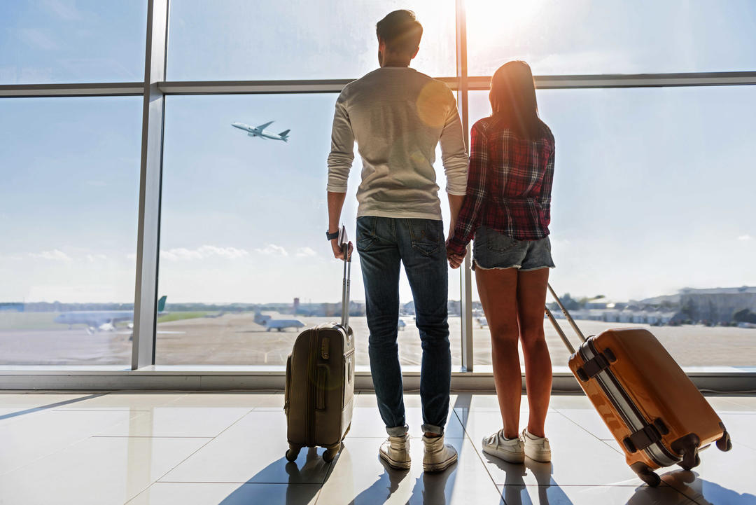 Чоловік та жінка спостерігають за польотом в аеропорту