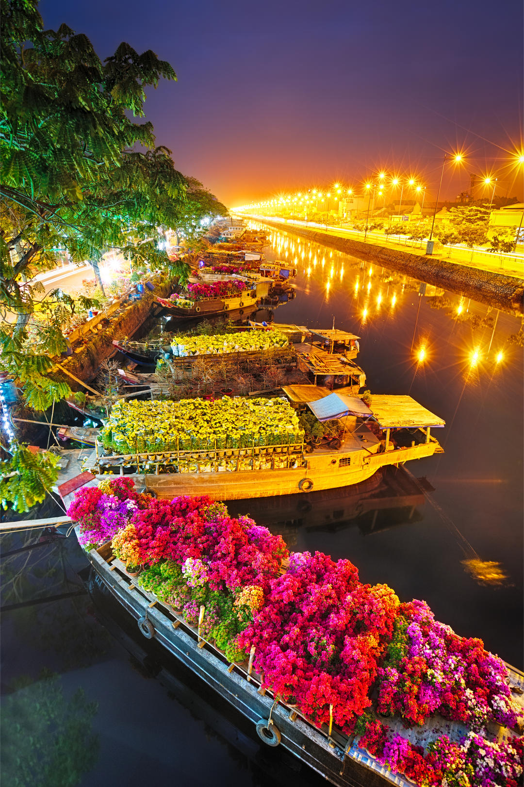 Вечірня річка з квітковими човнами в Хошимін