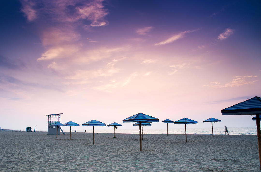 Пляжні парасольки на пляжі під час сходу сонця