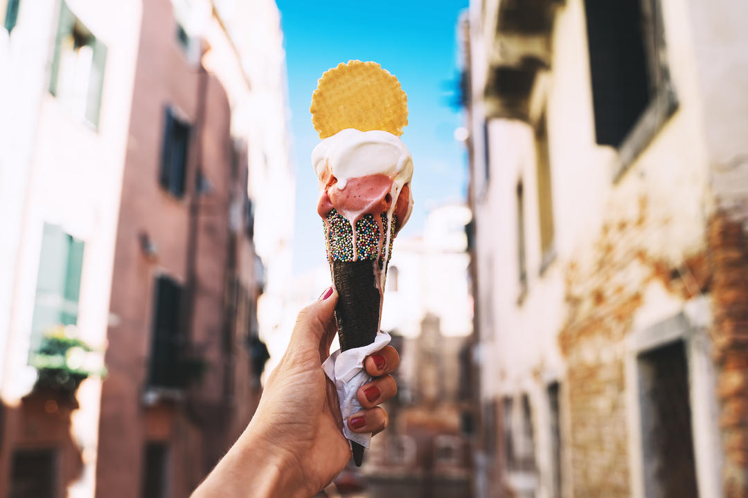 Морозиво в руці на фоні історичних будівель у Венеції.