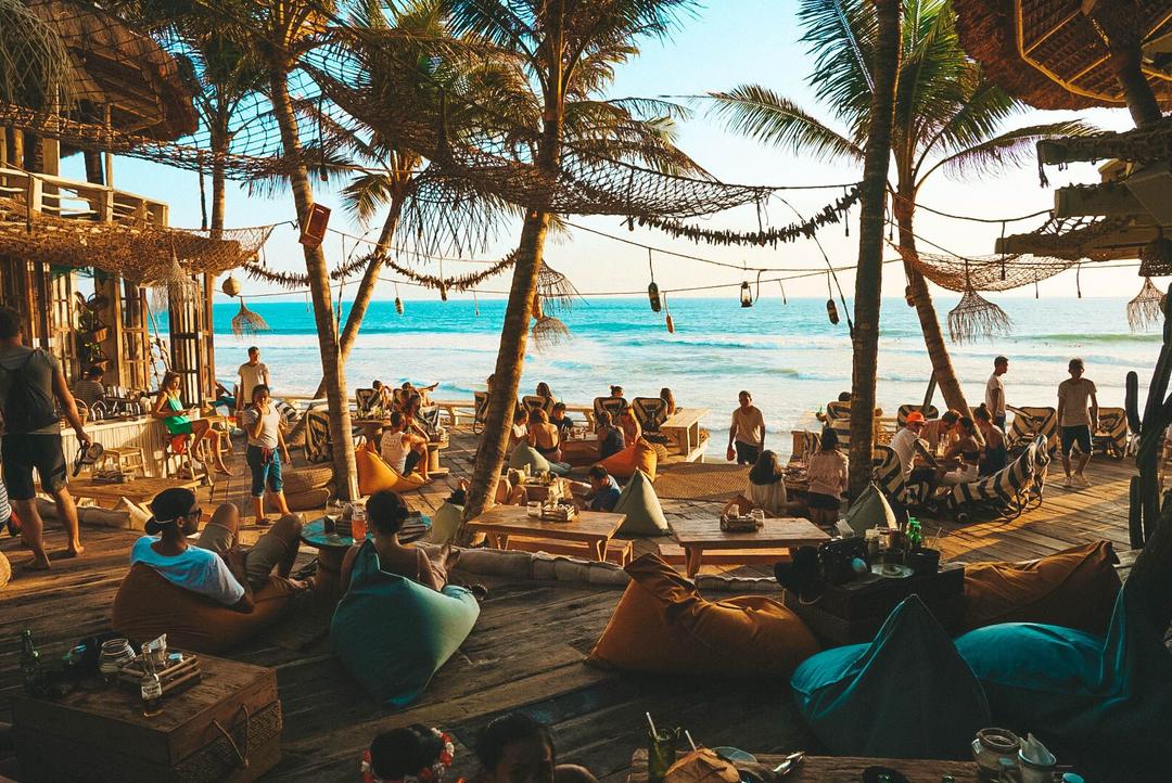 Люди відпочивають під пальмами на пляжі