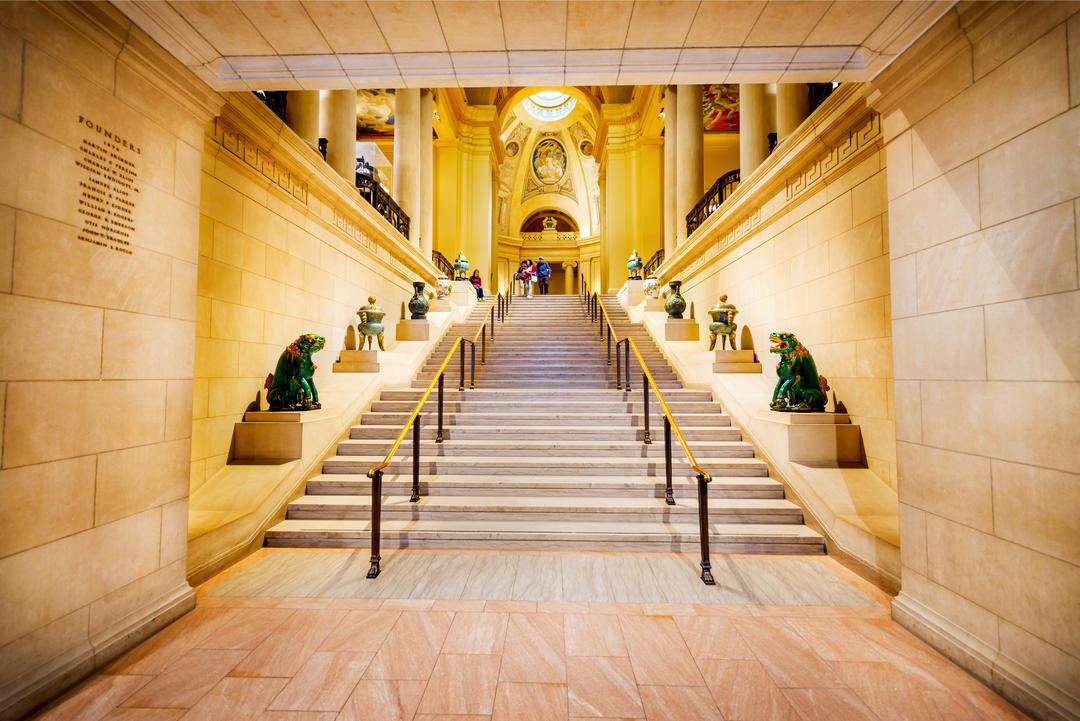 Вхідні сходи зі скульптурами в інтер'єрі музею