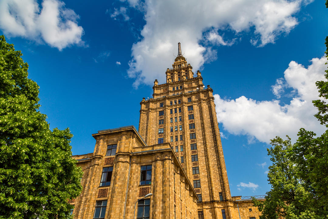Високий корпус Латвійської академії наук на фоні синього неба.