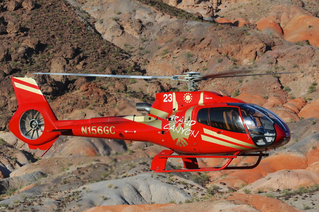 Червоний екскурсійний вертоліт у польоті