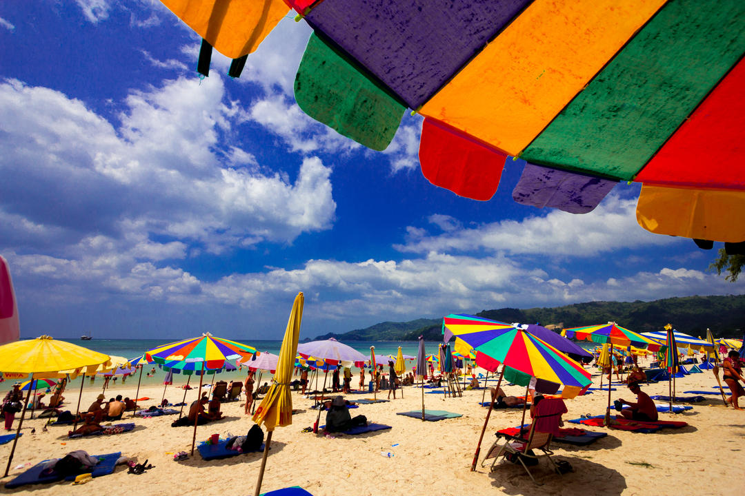 Туристи під парасольками на пляжі