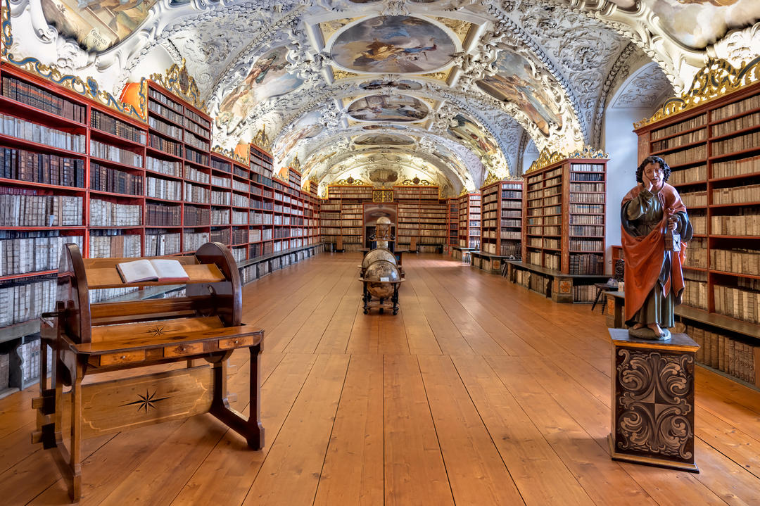 Колекція старовинних книг і глобусів у залі з фресками.