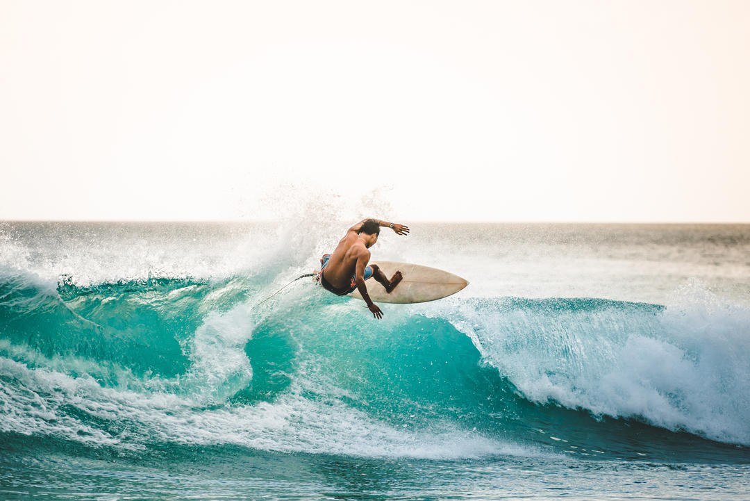 Чоловік ловить хвилі в океані на Балі.