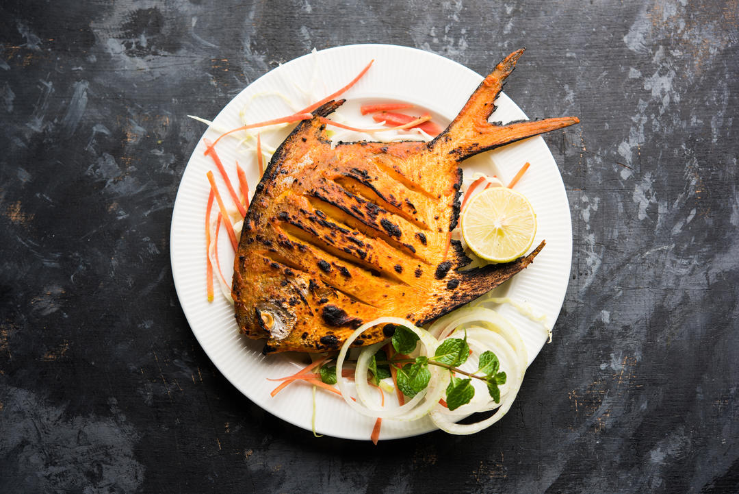 Риба прикрашена салатом з лимона, м'яти, капусти та моркви.