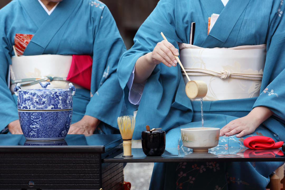 Дві дівчини у традиційних костюмах під час чайної церемонії.