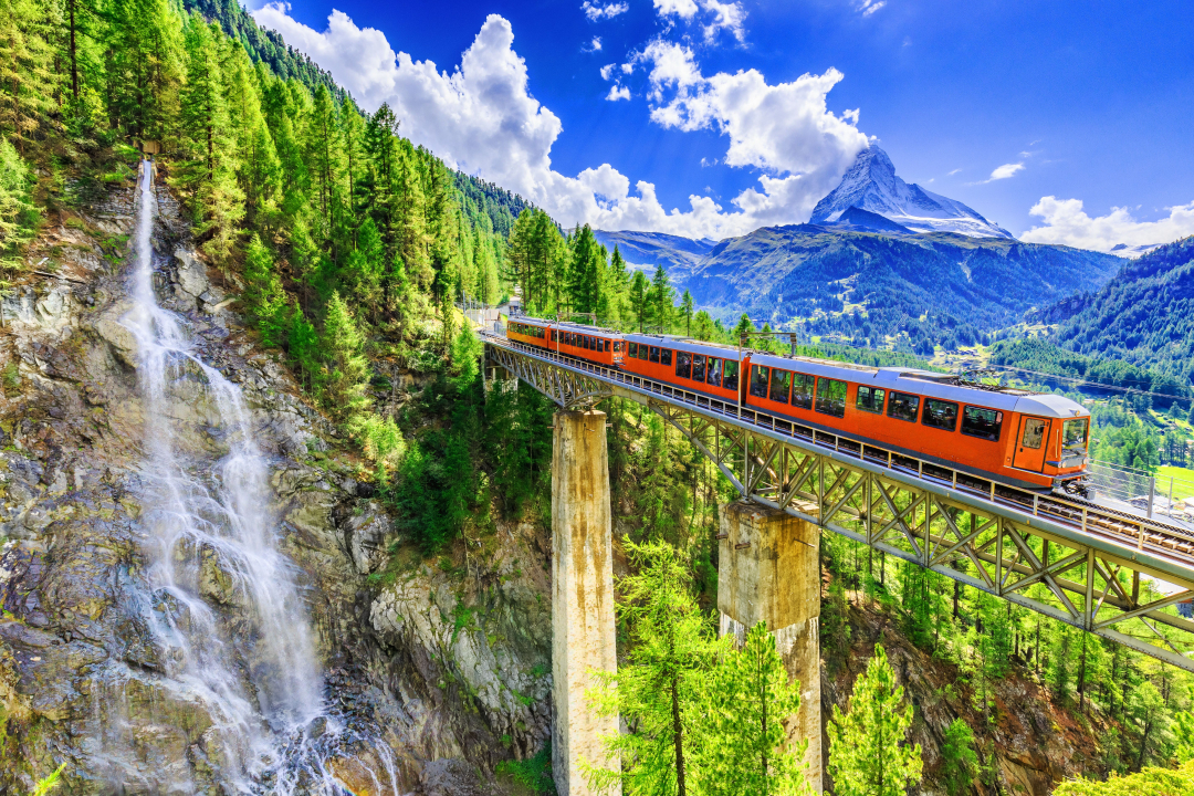 Туристичний поїзд з водоспадом та мостом. Церматт, Швейцарія.