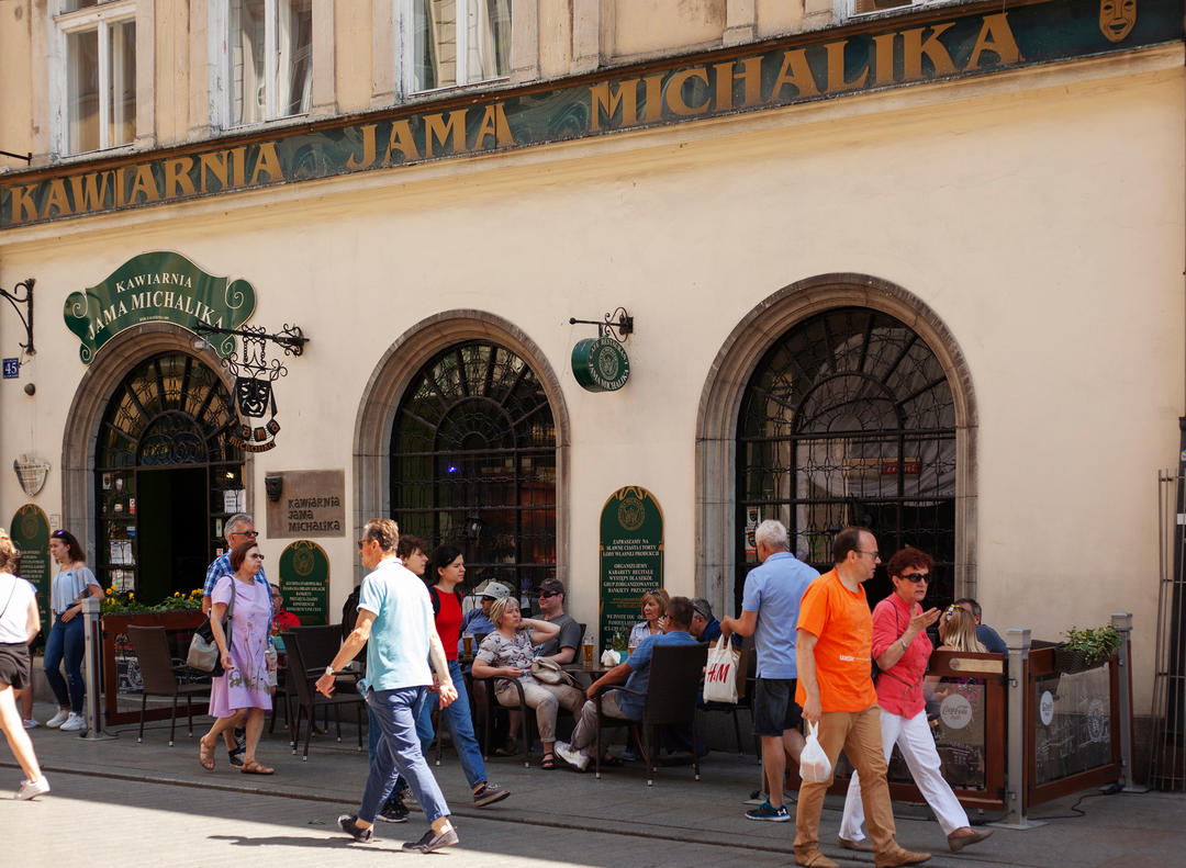 Туристи сидять за столиками перед кафе Jama Michalika