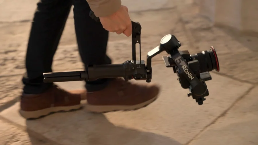 Оператор іде зі стабілізатором DJI Ronin RS 5 у руках і знімає на ходу